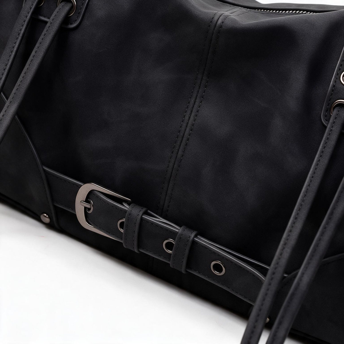Close-up of black belted satchel bag details