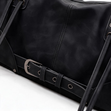 Close-up of black belted satchel bag details