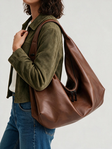 Side view of woman carrying brown slouchy tote bag