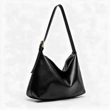 Black slouchy shoulder bag with long strap on a white background