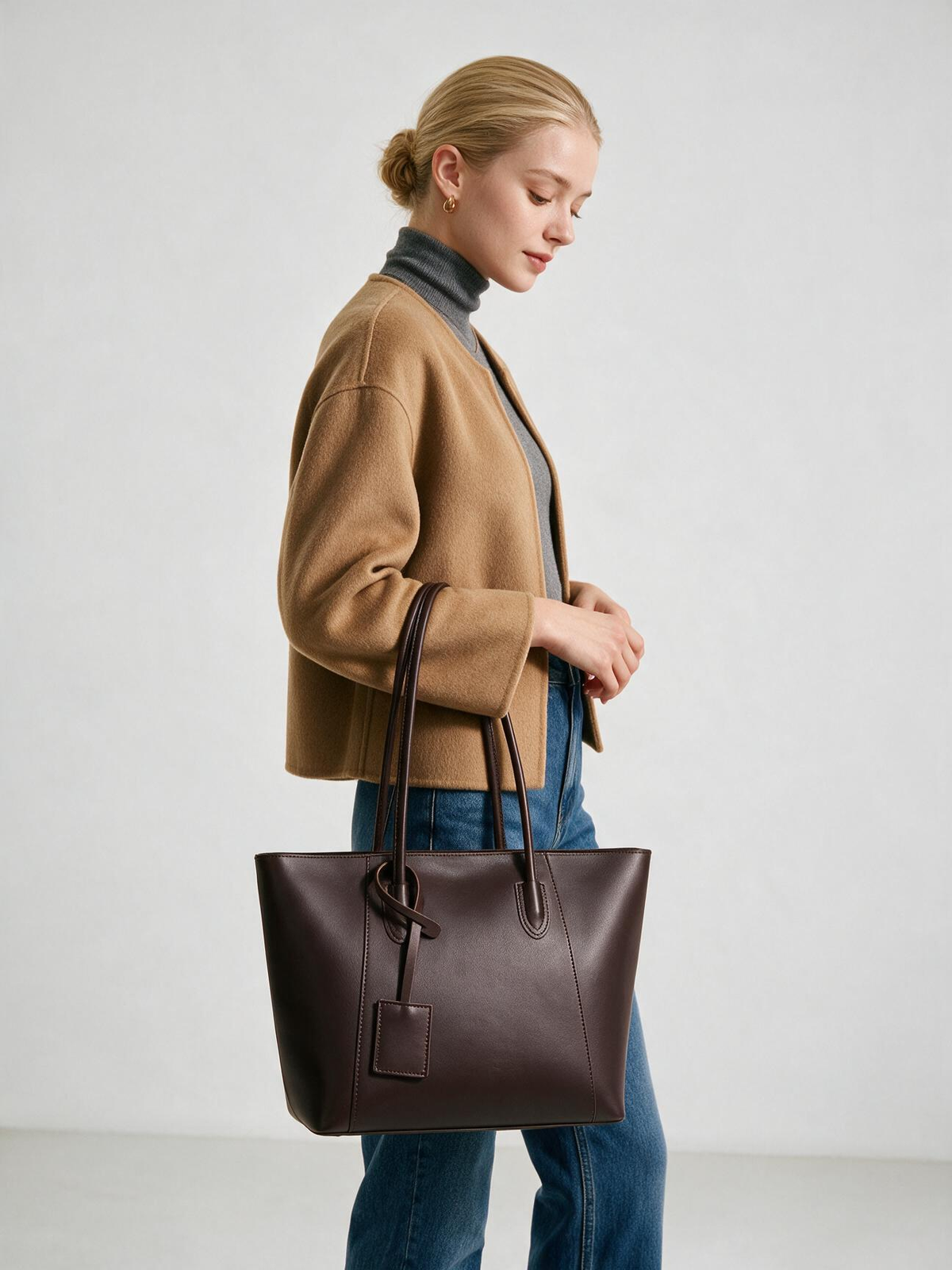 Woman carrying chocolate brown tote by its long handles