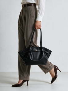 Model holding the black faux leather tote bag