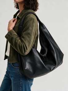 Woman styling the black slouchy shoulder tote