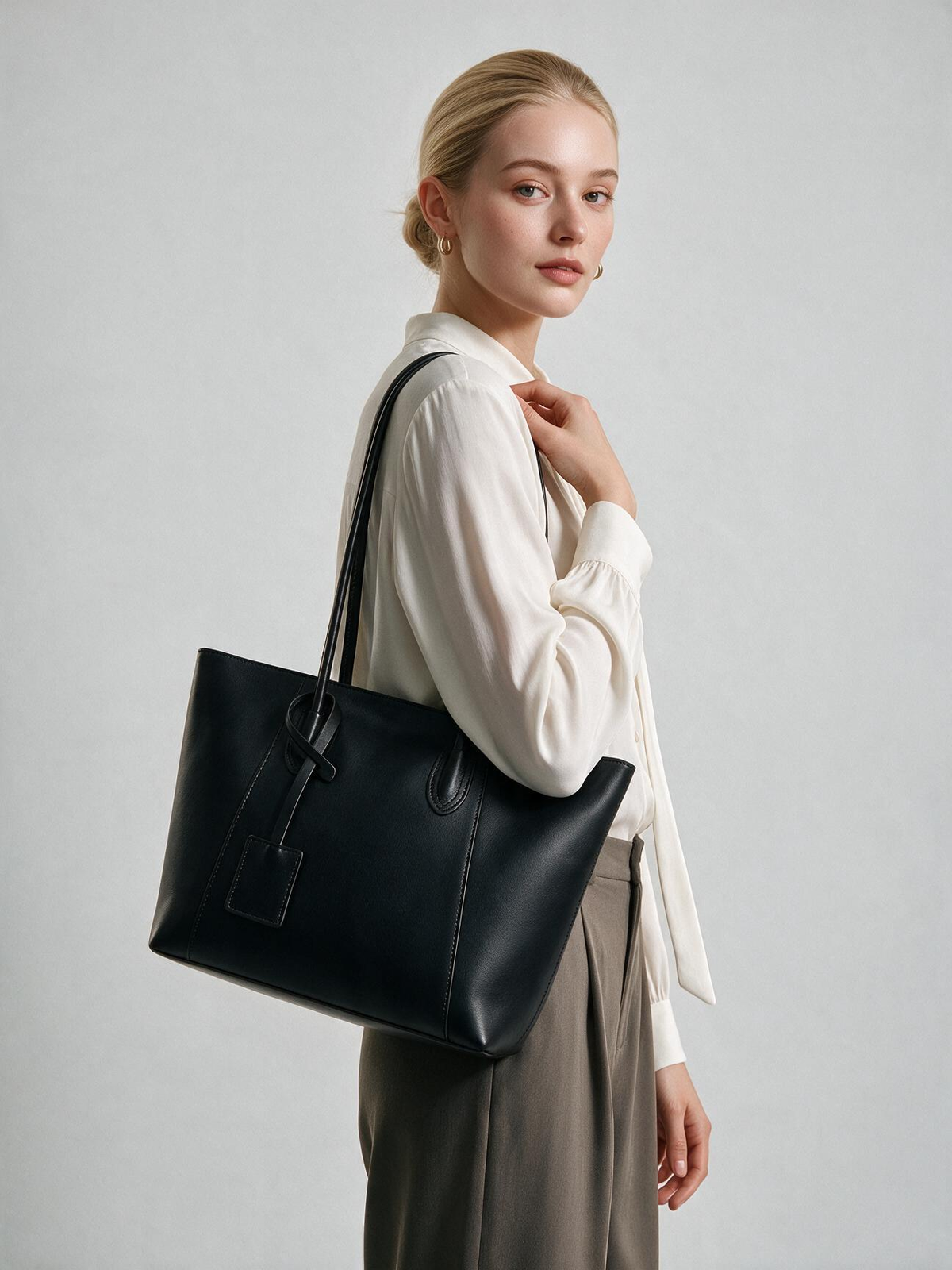Woman styling the black shoulder tote bag
