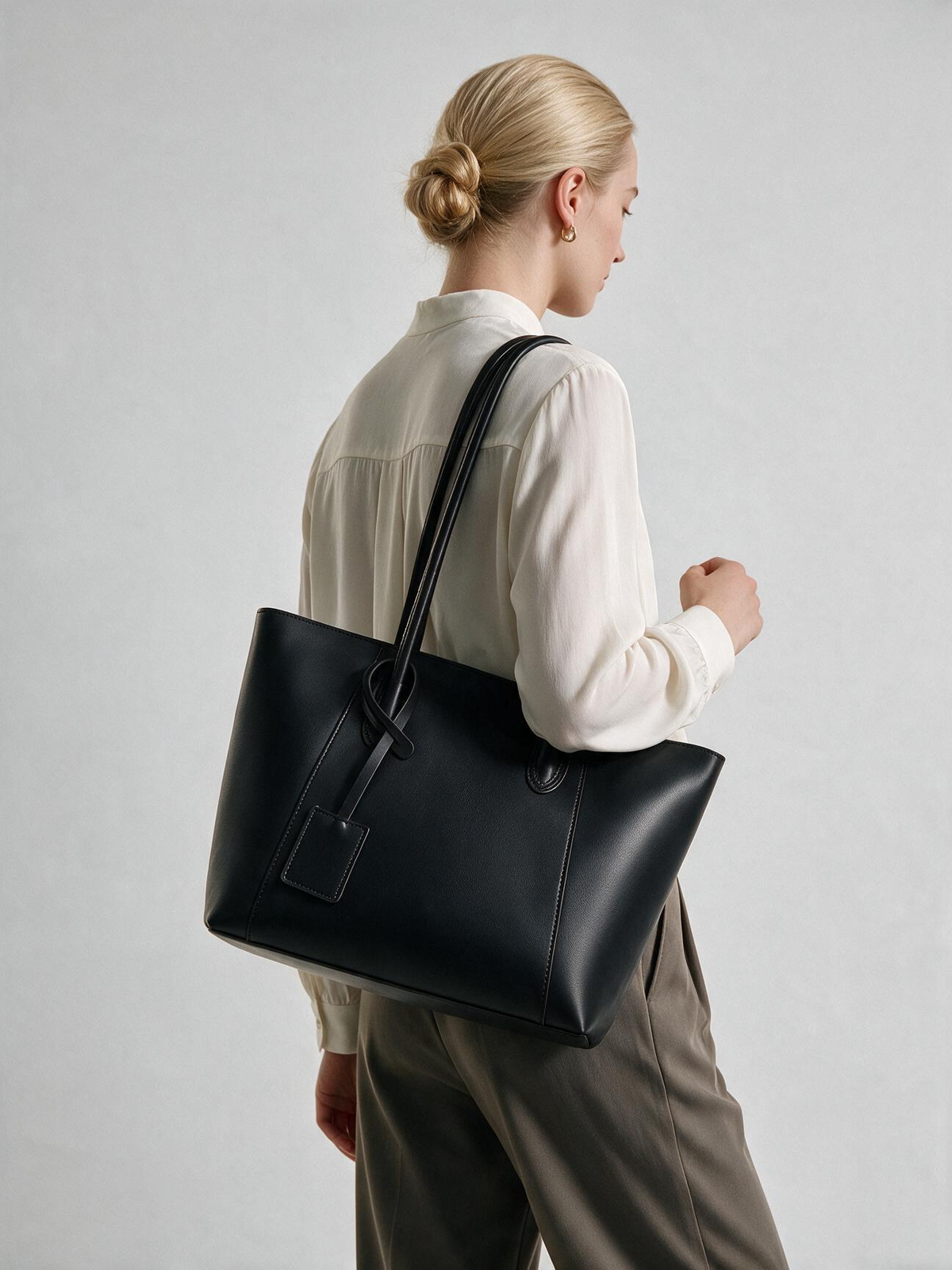 Black shoulder tote bag carried at the side