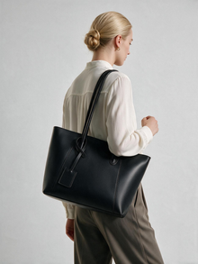 Black shoulder tote bag carried at the side