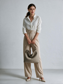 Model holding a taupe woven-look hobo bag with a light outfit