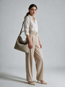 Model carrying the taupe woven-look bag with a white shirt and light trousers